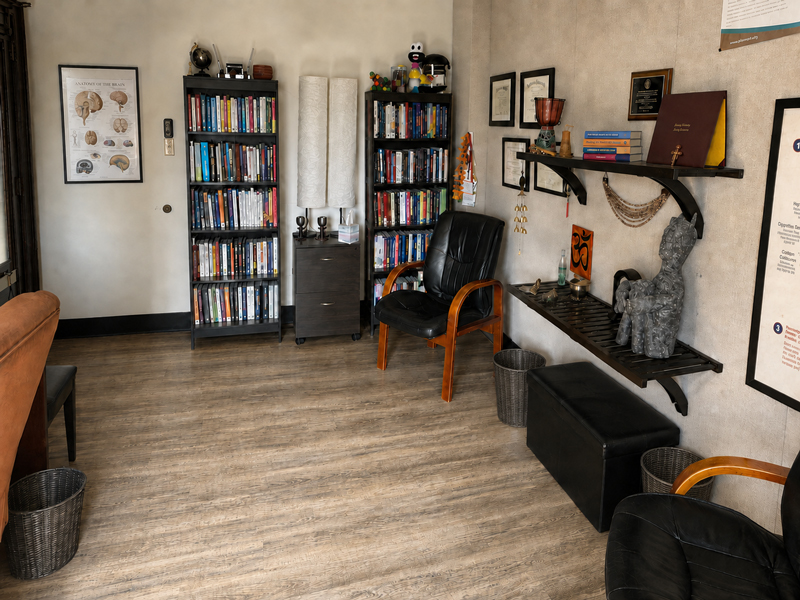 Second counseling treatment room at ACRS in Lancaster, PA, lined with clinical reference books, an anatomy of the brain chart, and framed clinician credentials